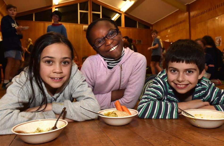 Liberton Christian School pupils (from left) Bethany Pantel (9), Malaika Ogebuehi (10) and Daniel Bretz (10) enjoy lentil dahl, carrots and rice - the type of food Syrian refugees might eat at refugee camps in Jordan. Photo by Gregor Richardson